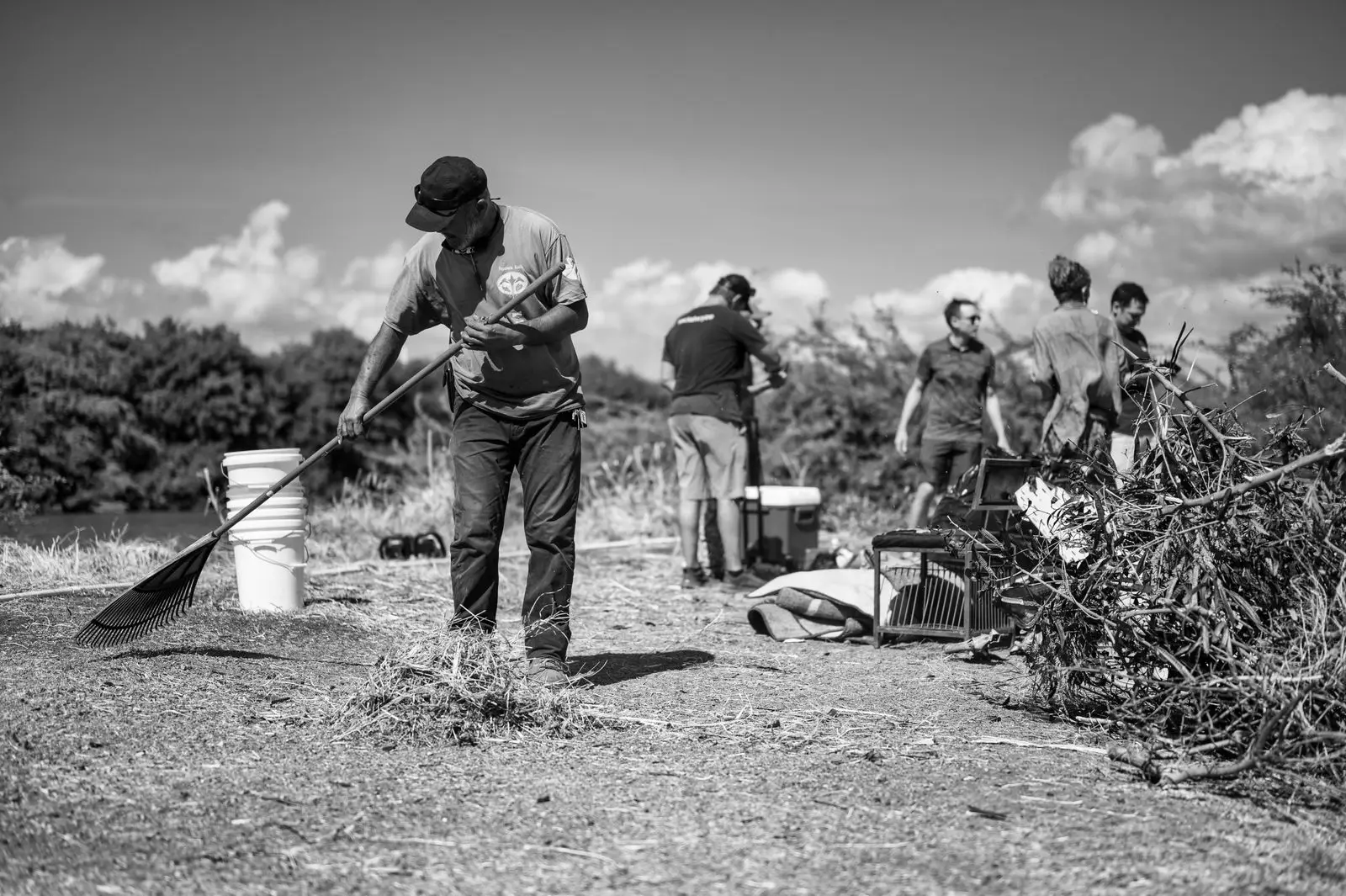Volunteers clearing brush along a river, seen at work